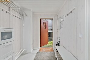 A narrow hallway with a wooden door leading to an outdoor area. - Modern apartment in Hafjell (Gudbrandsdalen)