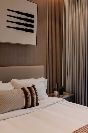 A hotel room with a bed, pillows, a nightstand, a vase with flowers, and a curtain. - Quiet Courtyard 2BR Suite with AC (Ciudad de México)