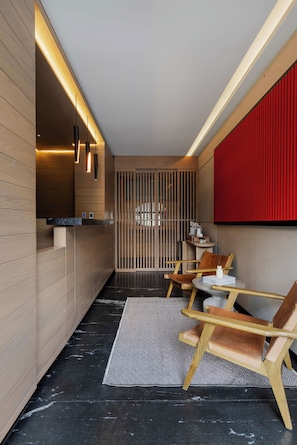 A modern interior with wooden panel walls, a black marble floor, and a seating area with wooden chairs and a small table. - Quiet Courtyard 2BR Suite with AC (Ciudad de México)