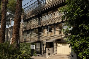 Ein modernes Gebäude mit mehrstöckiger Struktur, großen Fenstern und einem Balkon.
