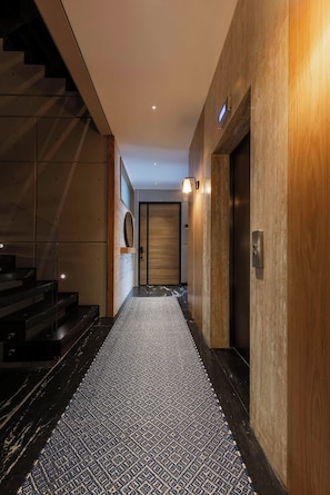A modern interior with a staircase, a patterned carpet, and a wooden wall. - Quiet Courtyard 2BR Suite with AC (Ciudad de México)