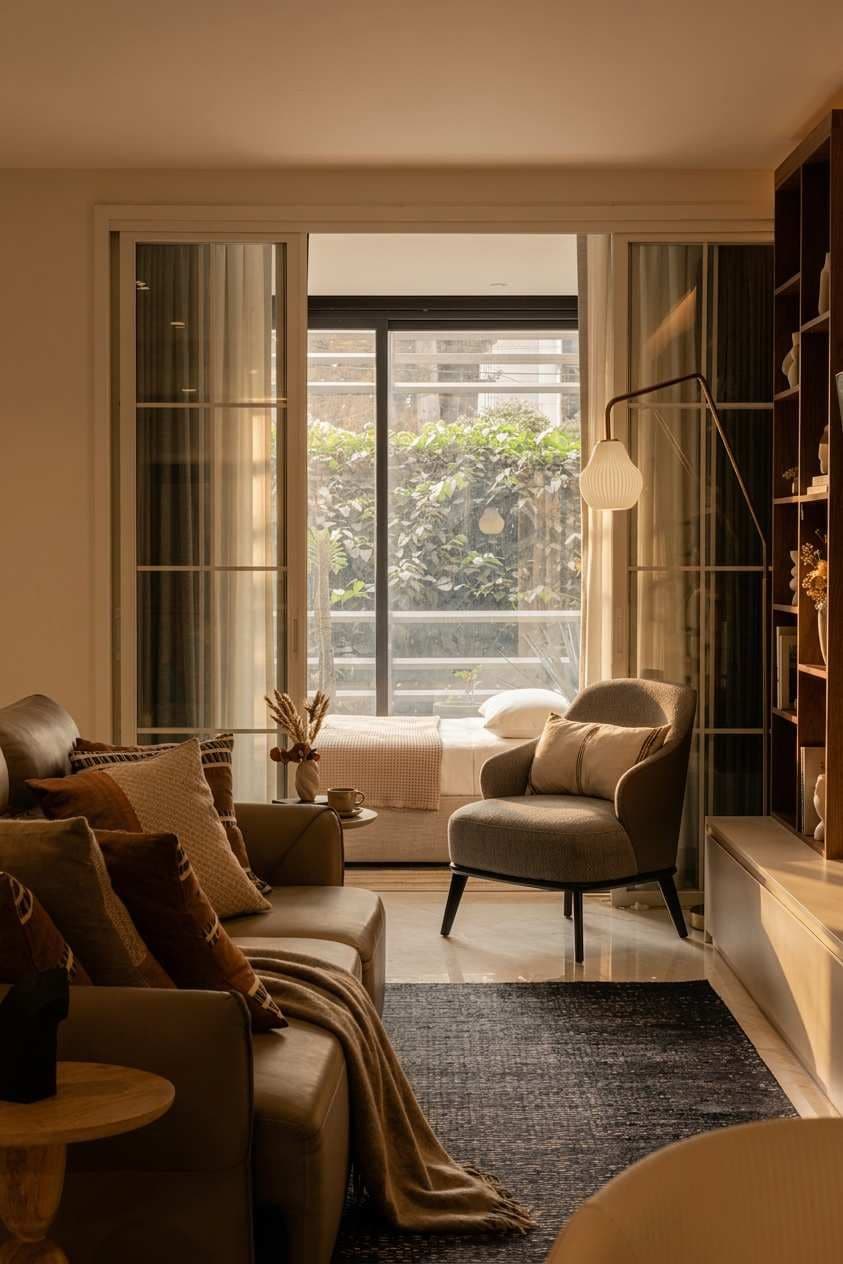 Ein modernes Wohnzimmer mit einer Couch, einem Sessel und einem Bücherregal.