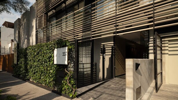 A modern building with a metal facade, a number sign, and a gated entrance. - Grand 3BR Apartment with Interior Balcony in Polanco (Ciudad de México)
