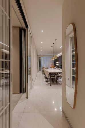 A modern dining area with a long table, chairs, pendant lighting, and a large mirror on the wall. - Grand 3BR Apartment with Interior Balcony in Polanco (Ciudad de México)