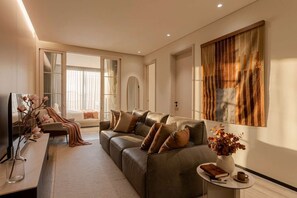 A modern living room with a leather sofa, a coffee table, and a large abstract painting. - Boutique Suite 2BR with AC and Balcony in Polanco (Ciudad de México)