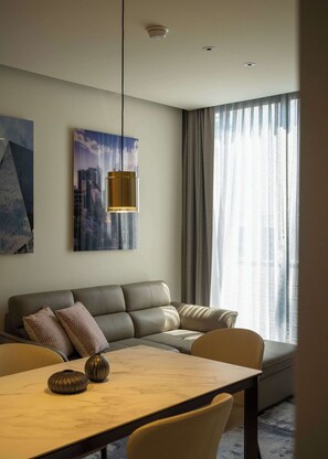 A modern living room with a sofa, a dining table, and a pendant light. - Family 2BR Apartment with Quiet Courtyard Balcony in Polanco (Ciudad de México)