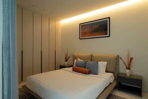 A modern bedroom with a bed, nightstands, a painting, and a wardrobe. - Family 2BR Apartment with Quiet Courtyard Balcony in Polanco (Ciudad de México)