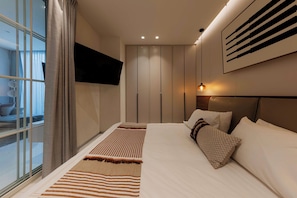 A modern hotel room with a bed, a TV mounted on the wall, and a large window with curtains. - Family 2BR Apartment with Quiet Courtyard Balcony in Polanco (Ciudad de México)