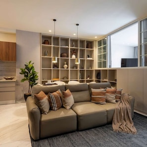 A modern living room with a sofa, a built-in shelving unit, and a large window. - Deluxe 1BR Apartment with Street-Facing Terrace in Polanco (Ciudad de México)