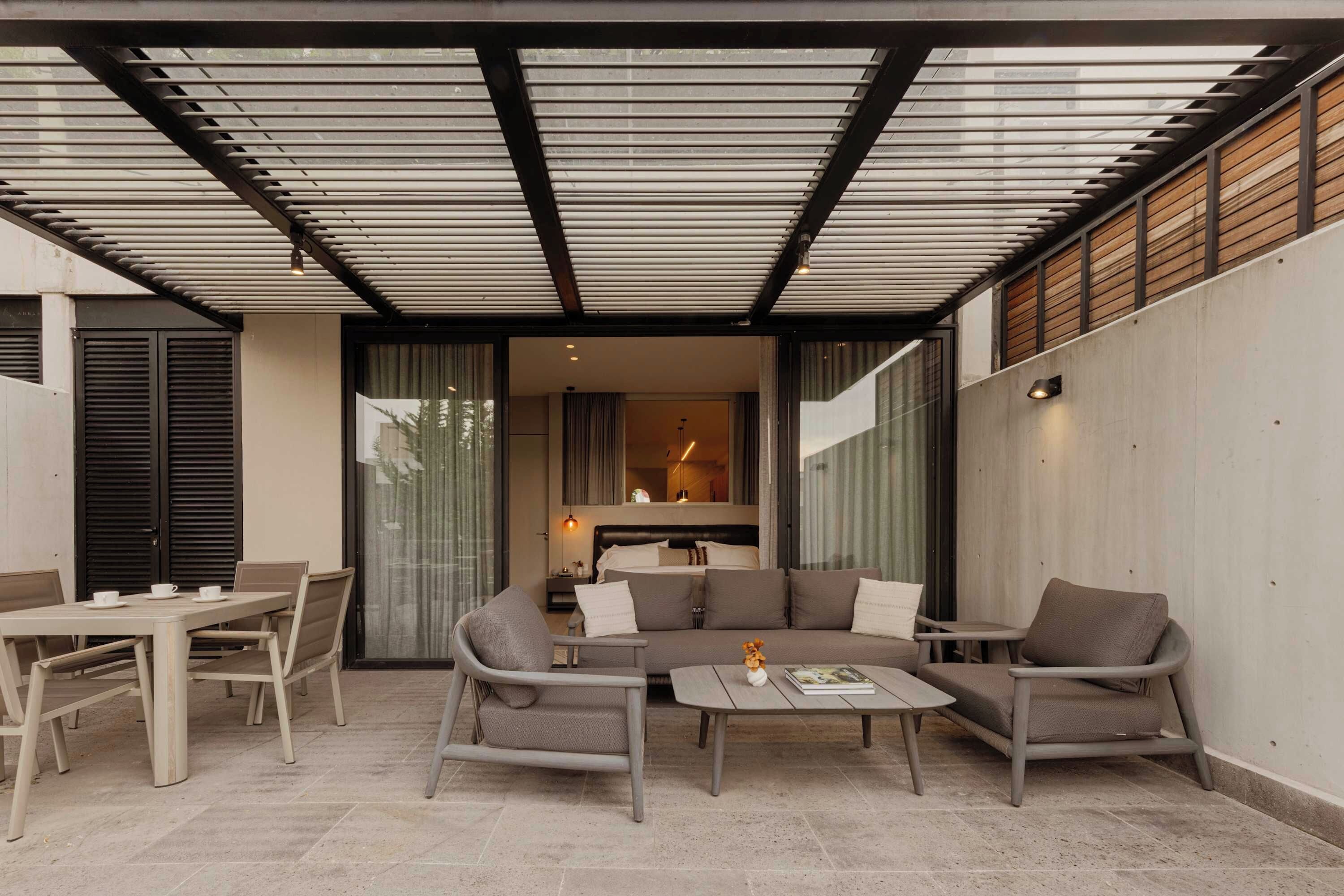 An outdoor patio area with a sofa set, a dining table, and chairs.