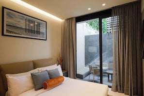 A bedroom with a bed, a framed picture on the wall, and a view of an outdoor patio area. - Garden 1BR Apartment with Interior Terrace in Polanco (Ciudad de México)