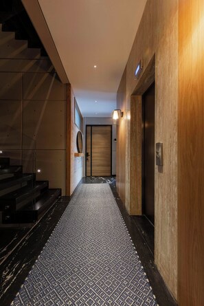 Ein modernes Interieur mit einer Treppe, einem gemusterten Teppich und einer Holzwand.