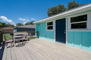 A house with a blue exterior, a wooden deck, and a door with a window. - Coastal Cocoanut Cottage ~ Whitaker Bayou~Bay (Sarasota)