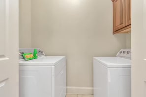 A laundry room with two white front-loading washing machines and a cabinet above one of them. - Gold&Brown!Oasis Pool HugeSuites Sleep10+!Galleria (Houston)
