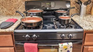 A kitchen with a stove, pots, and a red towel. - Gold&Brown!Oasis Pool HugeSuites Sleep10+!Galleria (Houston)