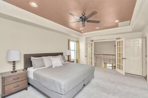 A bedroom with a bed, nightstands, lamps, a ceiling fan, and a door leading to a balcony. - Gold&Brown!Oasis Pool HugeSuites Sleep10+!Galleria (Houston)