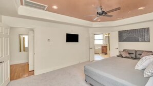 A bedroom with a bed, a ceiling fan, a TV, and a door leading to another room. - Gold&Brown!Oasis Pool HugeSuites Sleep10+!Galleria (Houston)