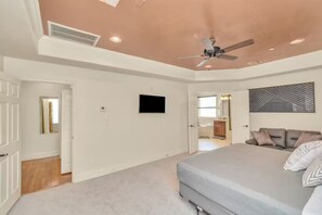 A bedroom with a bed, a ceiling fan, a TV, and a door leading to another room. - Gold&Brown!Oasis Pool HugeSuites Sleep10+!Galleria (Houston)