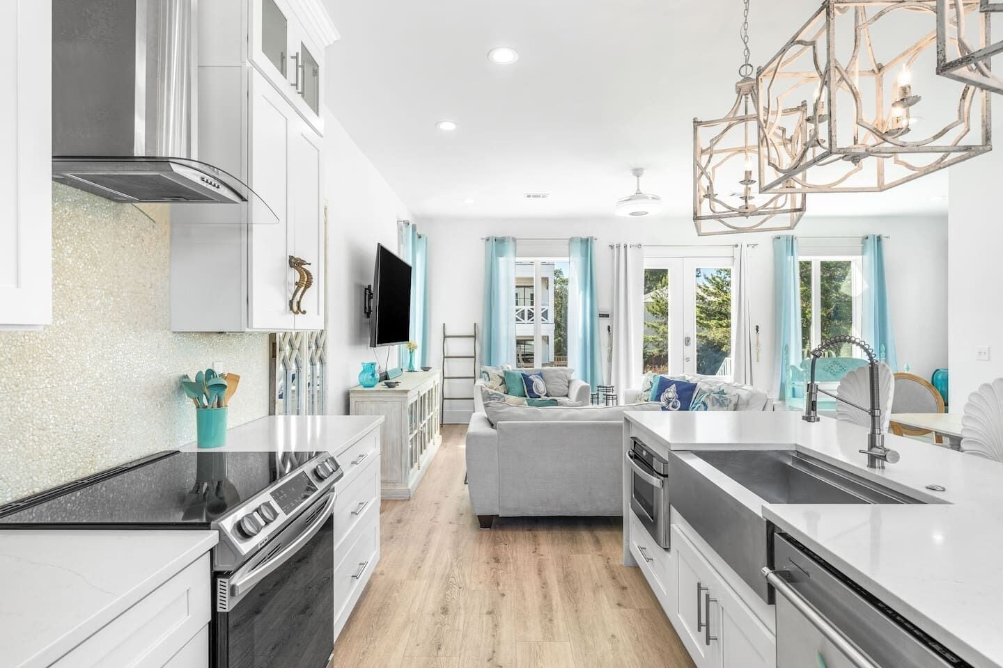 A modern kitchen with a central island, built-in appliances, and a dining area with a view.