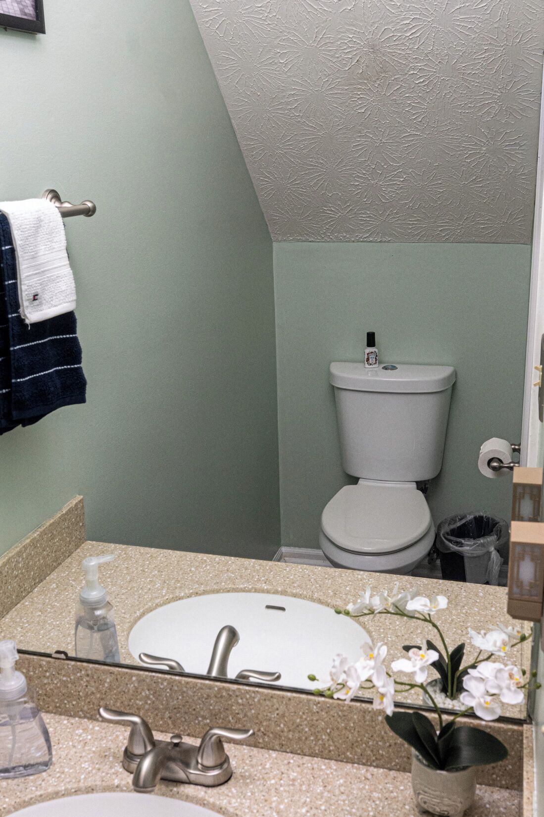 A bathroom with a sink, toilet, and a towel rack.
