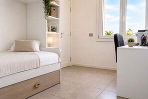 A bedroom with a bed, a desk, a chair, a window, and a plant. - Un Nido sul Garda by Case al Lago (Lonato)