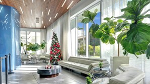 A modern lobby with a Christmas tree, leather sofas, and large windows. - *Amazing 1 BDR Resort Amenities Beach Pool Gym (Hallandale Beach)