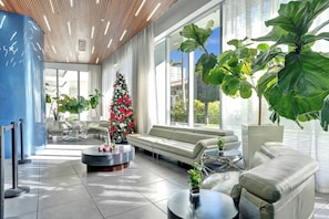Eine moderne Lobby mit einem Weihnachtsbaum, Ledersofas und großen Fenstern.