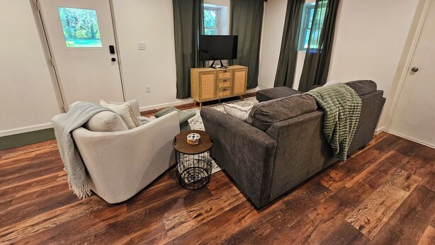 A living room with a sofa, armchair, and a small side table with a clock. - Charming, streamside, 3-bedroom country house in Confluence! (Confluence)