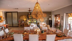 Un comedor con una gran mesa de madera, sillas y una lámpara colgante.