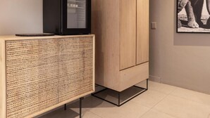 Una habitación con un armario de madera, un televisor encima y un cuadro en la pared.