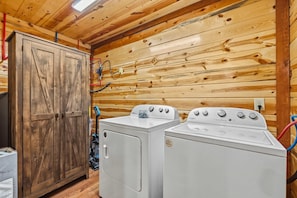 Ein Waschraum mit Holzwänden, einem Holzkabinett und zwei weißen Whirlpool Waschmaschinen.