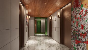 A hallway with marble flooring, wooden ceiling, and a green door.