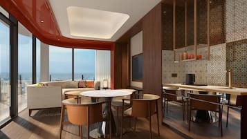 A modern hotel room with a dining area, large windows, and a city view.