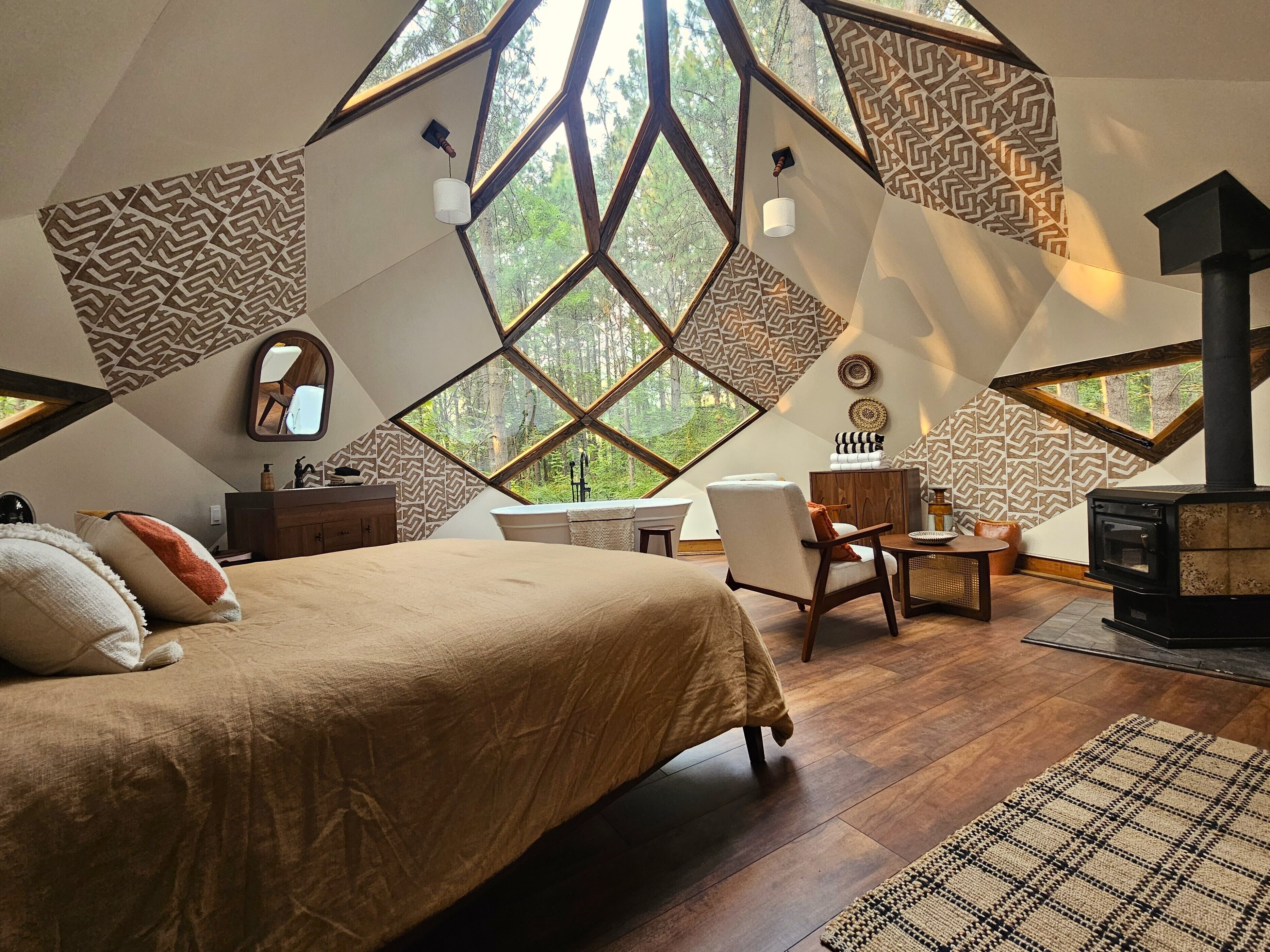 Une chambre à coucher avec un grand lit, un bureau, une chaise, une commode et une cheminée.
