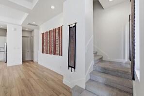 Ein modernes Interieur mit Treppe, Holzboden und Wanddekorationen.