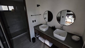 Ein modernes Badezimmer mit zwei Waschbecken, einem großen Spiegel und einem Handtuchhalter.