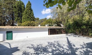 A paved courtyard with a white building, a green door, and a metal gate. - EXPERIENCE THE ELEGANCE OF THE FRENCH RIVIERA IN THIS EXCEPTIONAL 300 M² VILLA (Cannes)