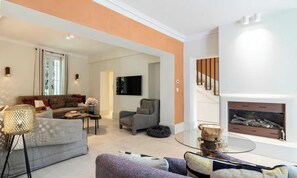 Una sala de estar moderna con sofá, sillones, una mesita de centro y una chimenea.
