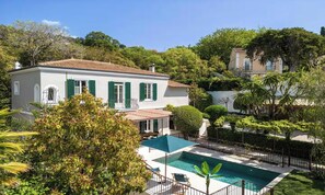 A villa with a swimming pool, surrounded by lush greenery and a hilly landscape. - EXPERIENCE THE ELEGANCE OF THE FRENCH RIVIERA IN THIS EXCEPTIONAL 300 M² VILLA (Cannes)