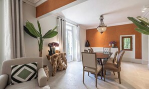 A dining area with a round table, chairs, and a chandelier. - EXPERIENCE THE ELEGANCE OF THE FRENCH RIVIERA IN THIS EXCEPTIONAL 300 M² VILLA (Cannes)