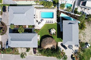 Ein Luftbild eines Wohngebiets mit mehreren Häusern, einem Schwimmbad und einer kleinen Gartenanlage.
