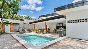 A modern outdoor pool area with a rectangular pool, lounge chairs, and a bar area. - Villa con Piscina Privada a 3 min de la Playa / Concierge incluido (Playa Grande)