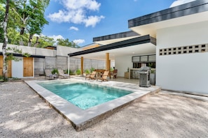 A modern outdoor pool area with a rectangular pool, lounge chairs, and a bar area. - Villa con Piscina Privada a 3 min de la Playa / Concierge incluido (Playa Grande)
