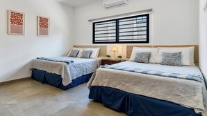 A bedroom with two beds, a ceiling fan, an air conditioning unit, and a window with blinds. - Villa con Piscina Privada a 3 min de la Playa / Concierge incluido (Playa Grande)