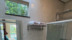 Ein modernes Badezimmer mit einer Duschkabine aus Glas, einer Toilette und einem Waschbecken mit Spiegel darüber.