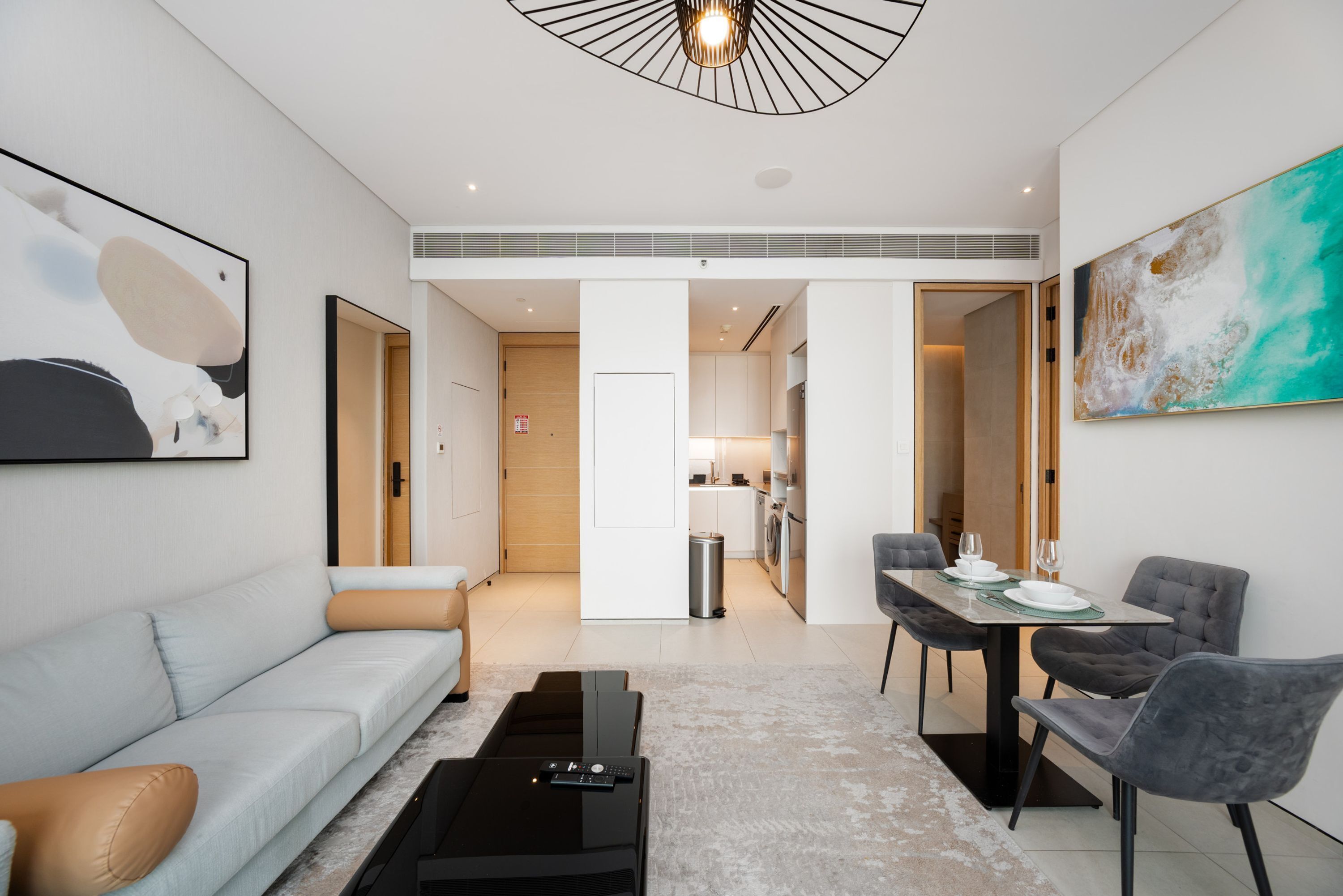 Un salon moderne comprenant un canapé, une table basse et un coin repas avec des chaises et une table.