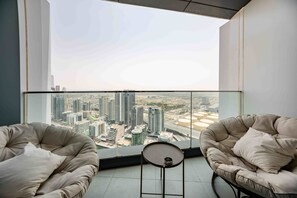 Ein modernes Zimmer mit zwei Ledersesseln, die zu einem großen Fenster mit Blick auf eine Stadtlandschaft ausgerichtet sind.