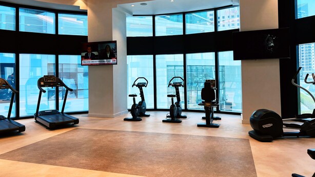 Ein modernes Fitnessstudio mit Laufbändern, Crosstrainern und einem stationären Fahrrad.