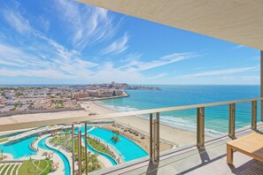 Un balcon avec vue sur une plage et une piscine.