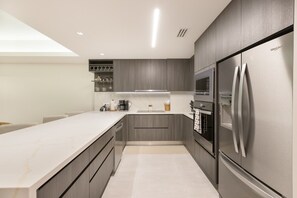Eine moderne Küche mit Einbauofen, Kühlschrank und Arbeitsplatte.
